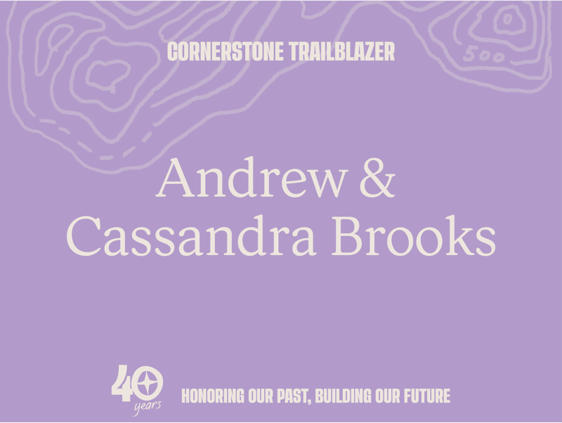 This image is a graphic celebrating Andrew & Cassandra Brooks as "Cornerstone Trailblazers." It features their names prominently, along with the text "Honoring Our Past, Building Our Future" and a "40 years" milestone. The background has a topographical map design with contour lines and the number 500, suggesting a connection to nature or achievement.